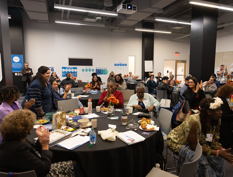 Large group of people gathered around multiple tables.