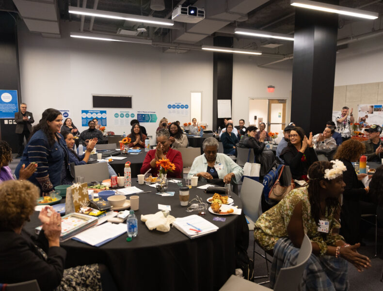 Large group of people gathered around multiple tables