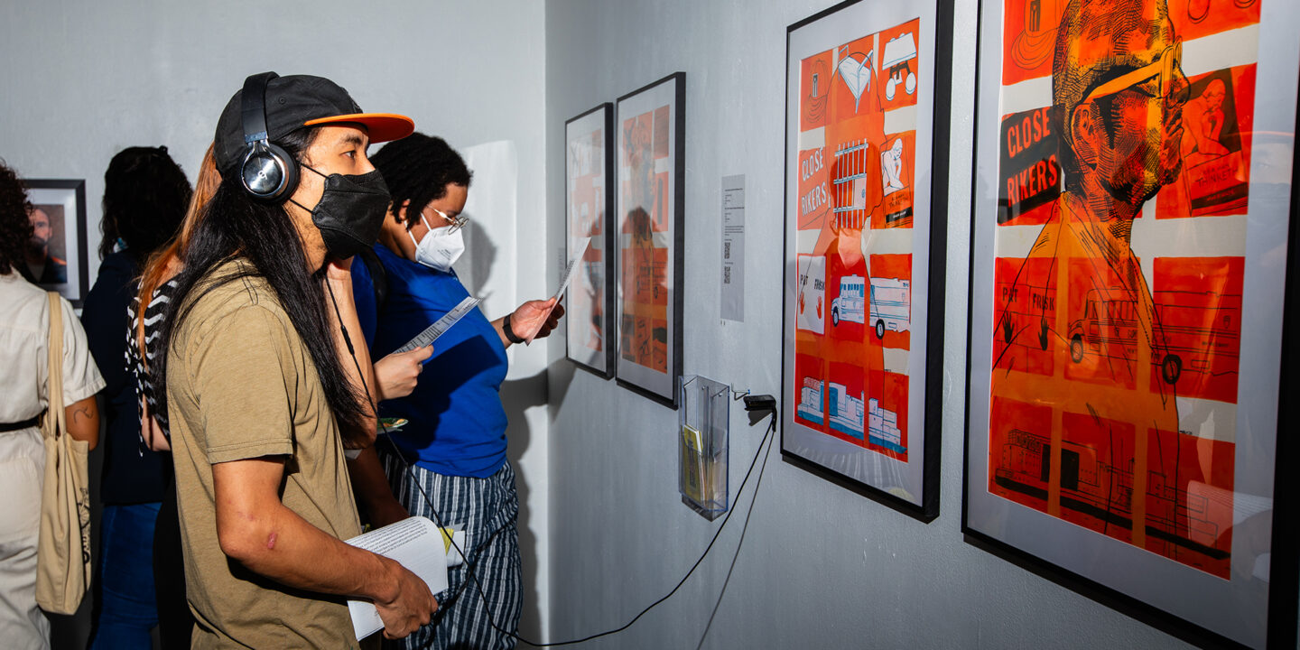 People in an art gallery looking at art and listening to information with headphones.