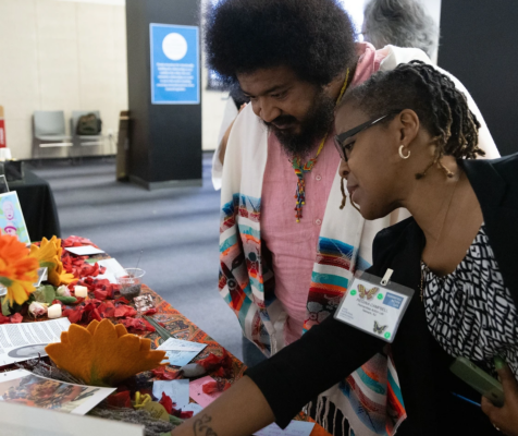 People at a convening, looking at materials together