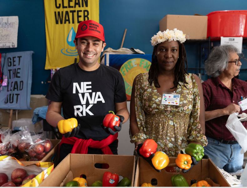 Two people holding colorful bell peppers