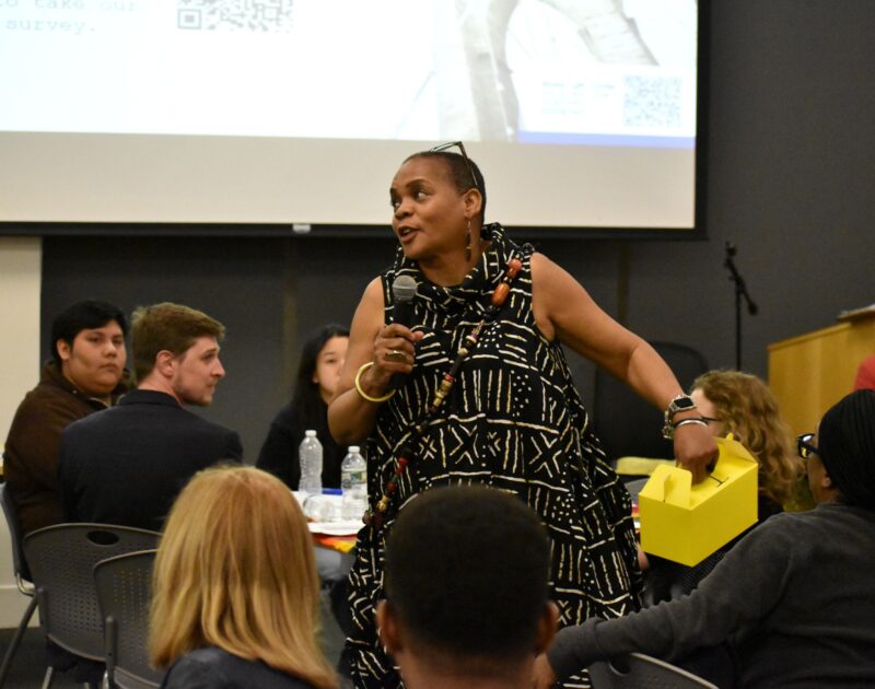 Woman on a microphone, speaking to a group